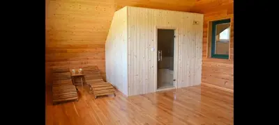 a room with two chairs and a wall with wood at Ranč Stojnšek in Rogaška Slatina