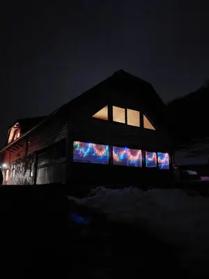 a house lit up at night with colorful windows at Ranč Stojnšek in Rogaška Slatina
