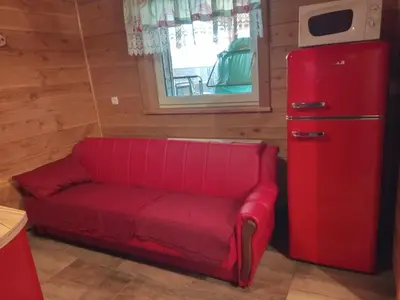 a red couch sitting next to a red refrigerator at Ranč Stojnšek in Rogaška Slatina