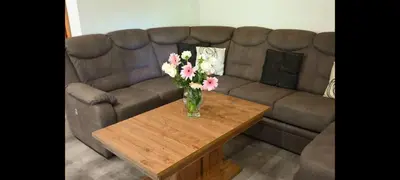 a vase of flowers on a coffee table in front of a couch at Ranč Stojnšek in Rogaška Slatina