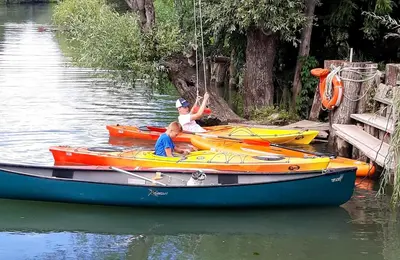 two people in a boat on the water at River Houses Ljubljanica in Ljubljana