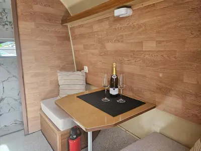 a small table with two glasses of wine on it at River Houses Ljubljanica in Ljubljana