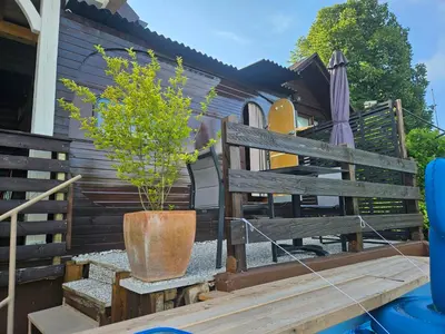a potted plant sitting on a bench next to a house at River Houses Ljubljanica in Ljubljana
