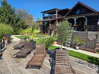 a row of wooden benches in front of a house at River Houses Ljubljanica in Ljubljana