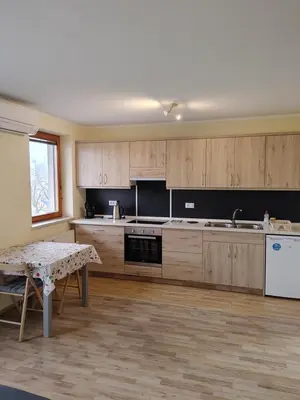 a kitchen with wooden cabinets and a table in it at Studio Maki in Bled
