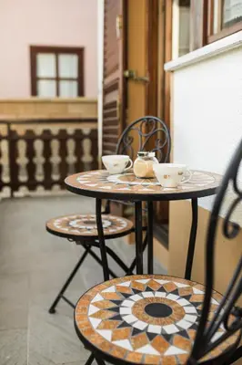 a table with two chairs and two cups on it at Apartma Lojz in Bovec