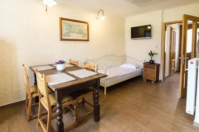 a dining room with a table and a bed at Apartma Lojz in Bovec