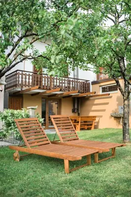 two chairs sitting on the grass in front of a house at Apartma Lojz in Bovec