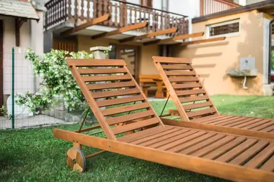 two deck chairs sitting on the grass in front of a house at Apartma Lojz in Bovec