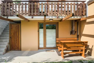 a house with a wooden table and a wooden stairs at Apartma Lojz in Bovec
