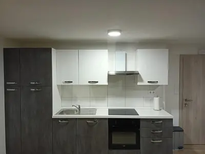 a kitchen with white cabinets and a sink at APARTMAJI KISILAK in Rogašovci