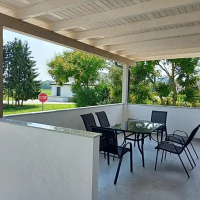 a patio with a table and chairs and a stop sign at APARTMAJI KISILAK in Rogašovci