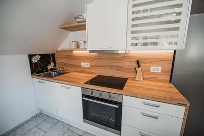a kitchen with white cabinets and a stove top oven at Apartments Rozalija in Preddvor