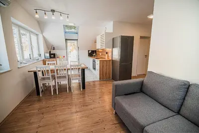 a living room with a couch and a table and a kitchen at Apartments Rozalija in Preddvor