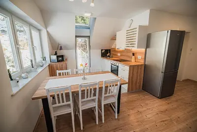 a kitchen with a dining table and a refrigerator at Apartments Rozalija in Preddvor