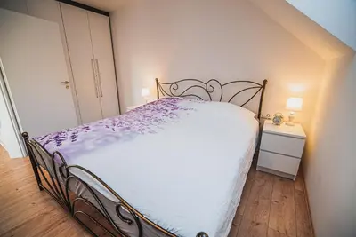 a bedroom with a bed with a white bedspread at Apartments Rozalija in Preddvor
