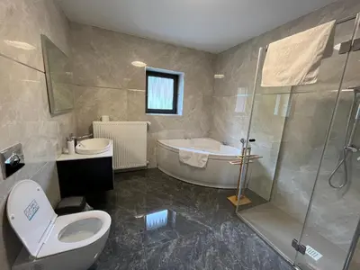 a bathroom with a tub and a toilet and a shower at Two Panorama Apartments in Bovec