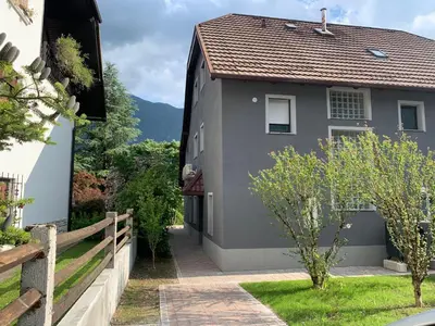 a gray house with a fence and a yard at Two Panorama Apartments in Bovec