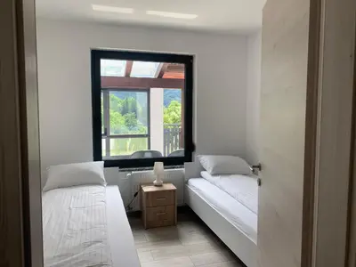 a bedroom with two beds and a window at Two Panorama Apartments in Bovec