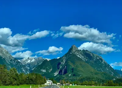 a road in front of a mountain range at Two Panorama Apartments in Bovec