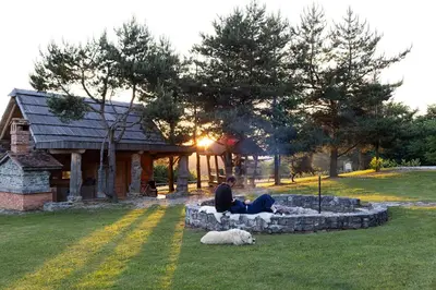 a couple of people sitting in a park with a dog at Holiday Home Ernest Železni with hot tub in Ivančna Gorica