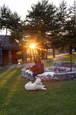a couple sitting on some rocks with a dog at Holiday Home Ernest Železni with hot tub in Ivančna Gorica