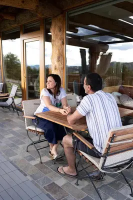 a man and a woman sitting at a table at Holiday Home Ernest Železni with hot tub in Ivančna Gorica