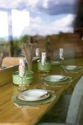 a wooden table with plates and glasses on it at Holiday Home Ernest Železni with hot tub in Ivančna Gorica