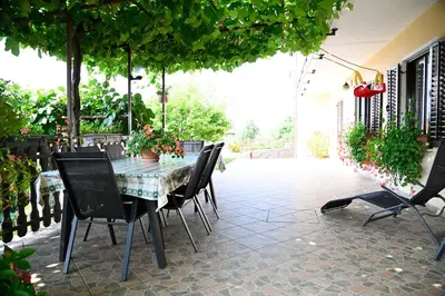 a patio with a table and chairs on a patio at Apartma Čuk in Dutovlje