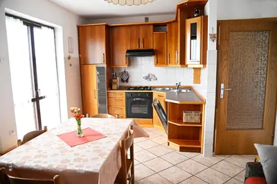 a kitchen with a table with a vase of flowers on it at Apartma Čuk in Dutovlje