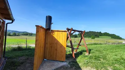 a wooden out door in a field at Unique wooden holiday house in nature in Lukovica pri Domžalah