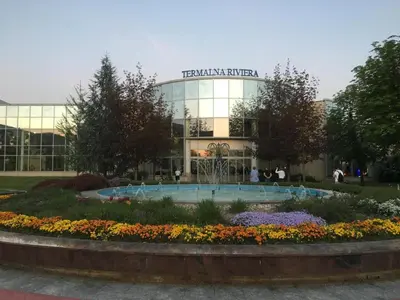 a building with a fountain and flowers in front of it at Apartmán Perspekta 196 in Čatež ob Savi