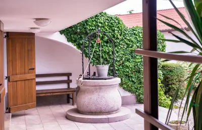 a large stone fountain in a patio with a bench at Hiša Orel (Orel House) in Križ