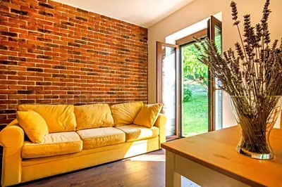 a living room with a couch and a brick wall at Danilo's Resort, Vipavska dolina in Dobravlje