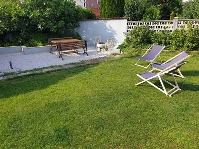 a couple of chairs and a bench in a yard at Huge BBQ Garden 2, Spacious Flat, AC, Free Parking 2 in Ljubljana