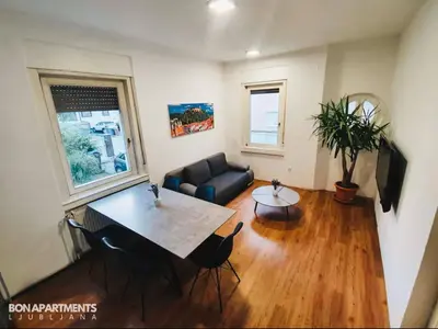 a living room with a table and a couch at Huge BBQ Garden 2, Spacious Flat, AC, Free Parking 2 in Ljubljana