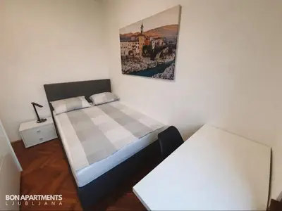a small bedroom with a bed and a table at Huge BBQ Garden 2, Spacious Flat, AC, Free Parking 2 in Ljubljana