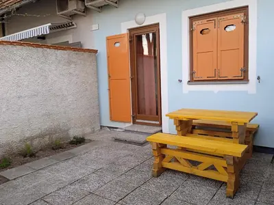 a wooden bench sitting next to a building with a door at Čebelica, apartma 101, Terme Čatež in Brežice