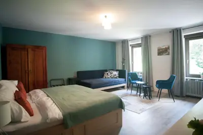 a bedroom with blue walls and a bed and a couch at Apartma Ajda in Železniki