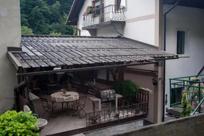 an outdoor patio with a table and chairs on a building at Apartma Ajda in Železniki