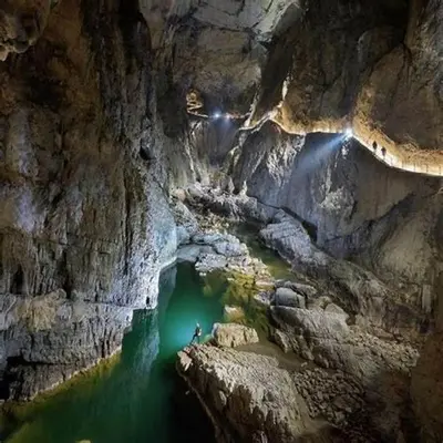 a person standing on a rock in a cave at Apartma Ajda in Železniki