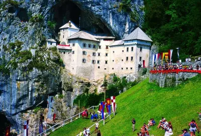 a castle sitting on top of a hill with people at Apartma Ajda in Železniki