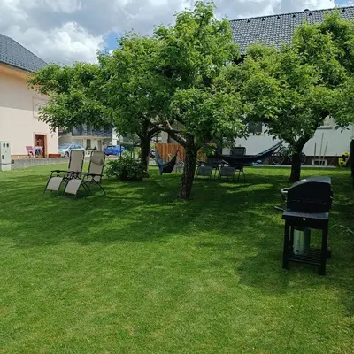 a park with chairs and a hammock and trees at Studio Mici in Bled