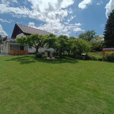 a yard with two chairs in front of a house at Studio Mici in Bled