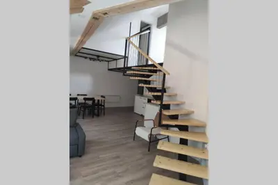 a spiral staircase in a room with a table at Bovec Loft apartment in Bovec