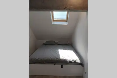 a bed in a small room with a window at Bovec Loft apartment in Bovec