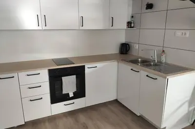 a kitchen with white cabinets and a sink and a stove at Bovec Loft apartment in Bovec