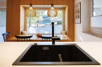 a kitchen sink with two lights and a table at Vila Slavc, cosy apartment near the lake in Bled