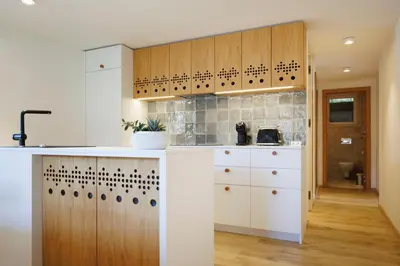 a kitchen with white counters and wooden cabinets at Vila Slavc, cosy apartment near the lake in Bled