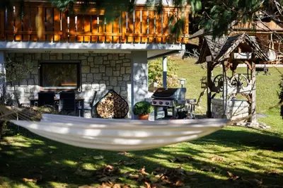 a white hammock in front of a house at Vila Slavc, cosy apartment near the lake in Bled